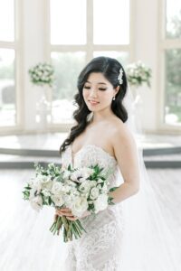 bride holding all white wedding bouquet
