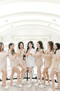 wedding party pops champagne while getting ready