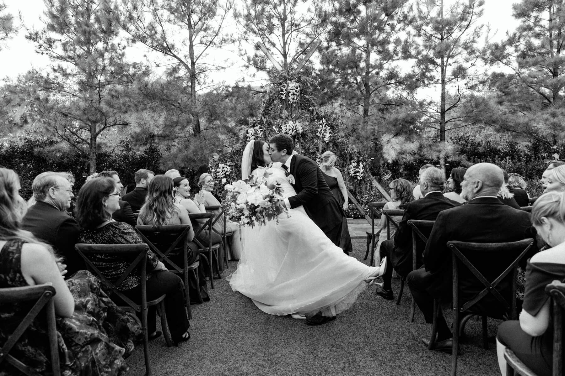 Bride and groom kissing during ceremony exit at Hotel Drover