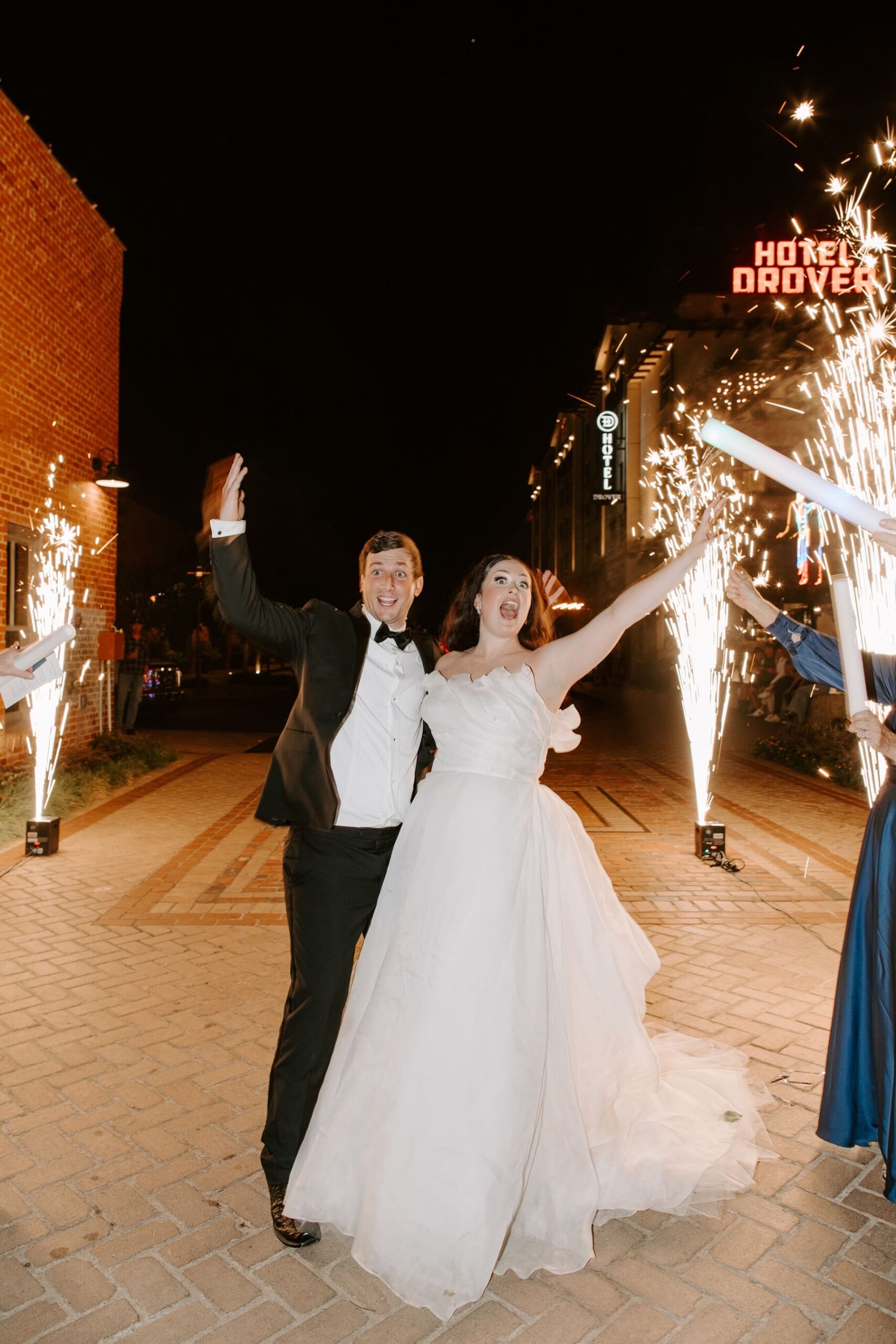 Bride and groom cheering during wedding reception exit at Hotel Drover