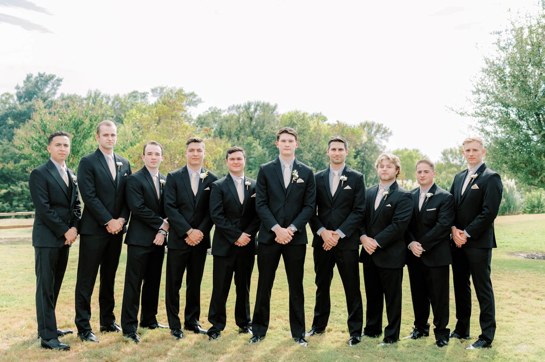 Groom and groomsmen in black suits at wedding at The Springs in McKinney