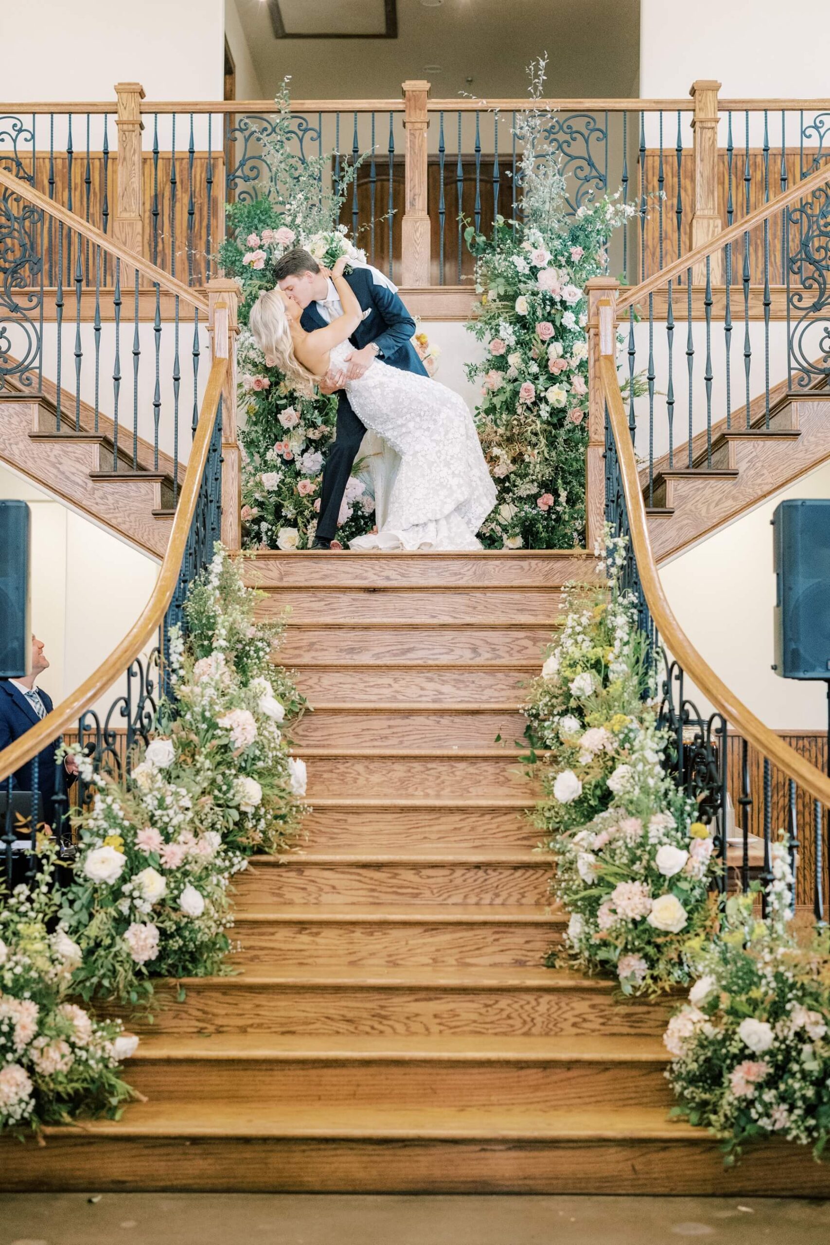 Groom dipping bride on grand staircase at The Springs in McKinney