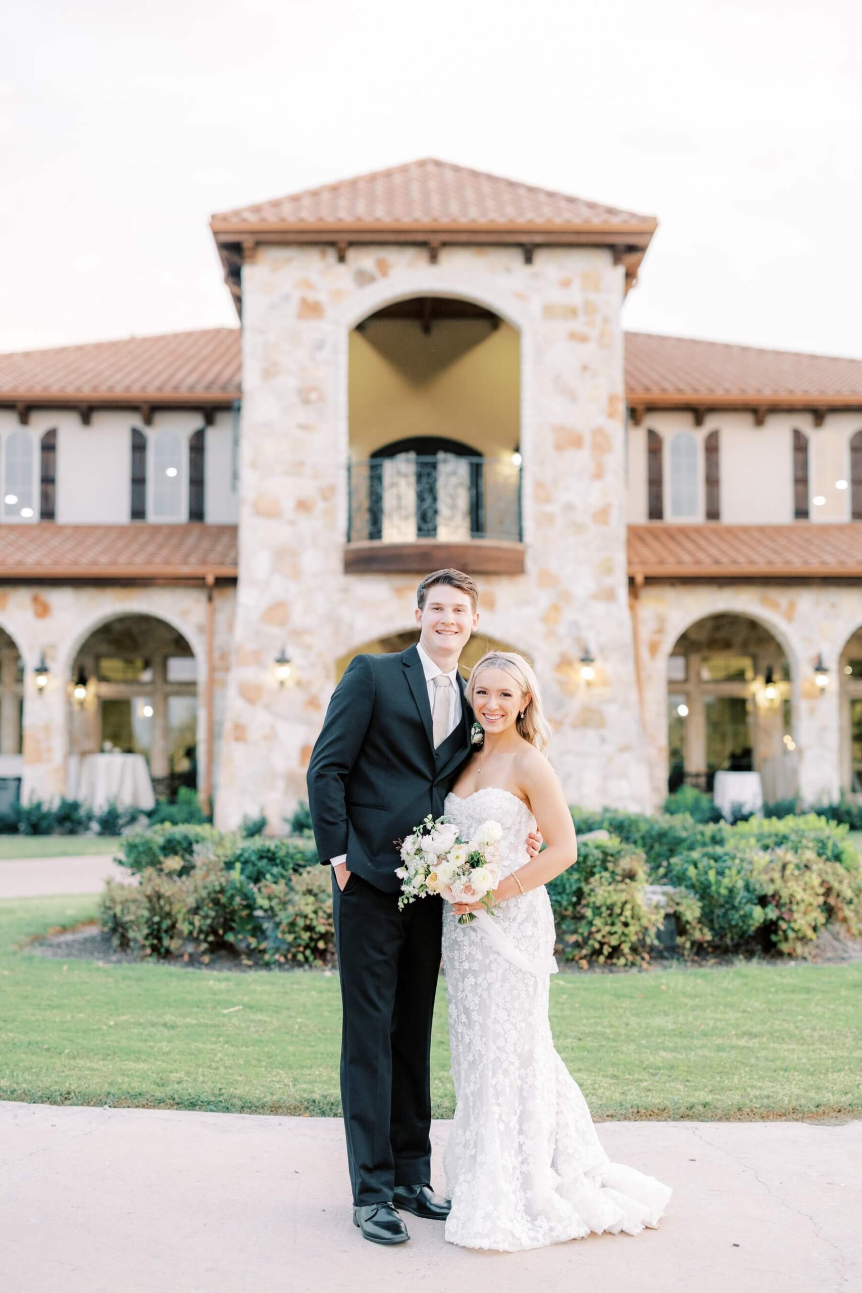Bride and groom standing in front of Tuscany Hill at The Springs in McKinney