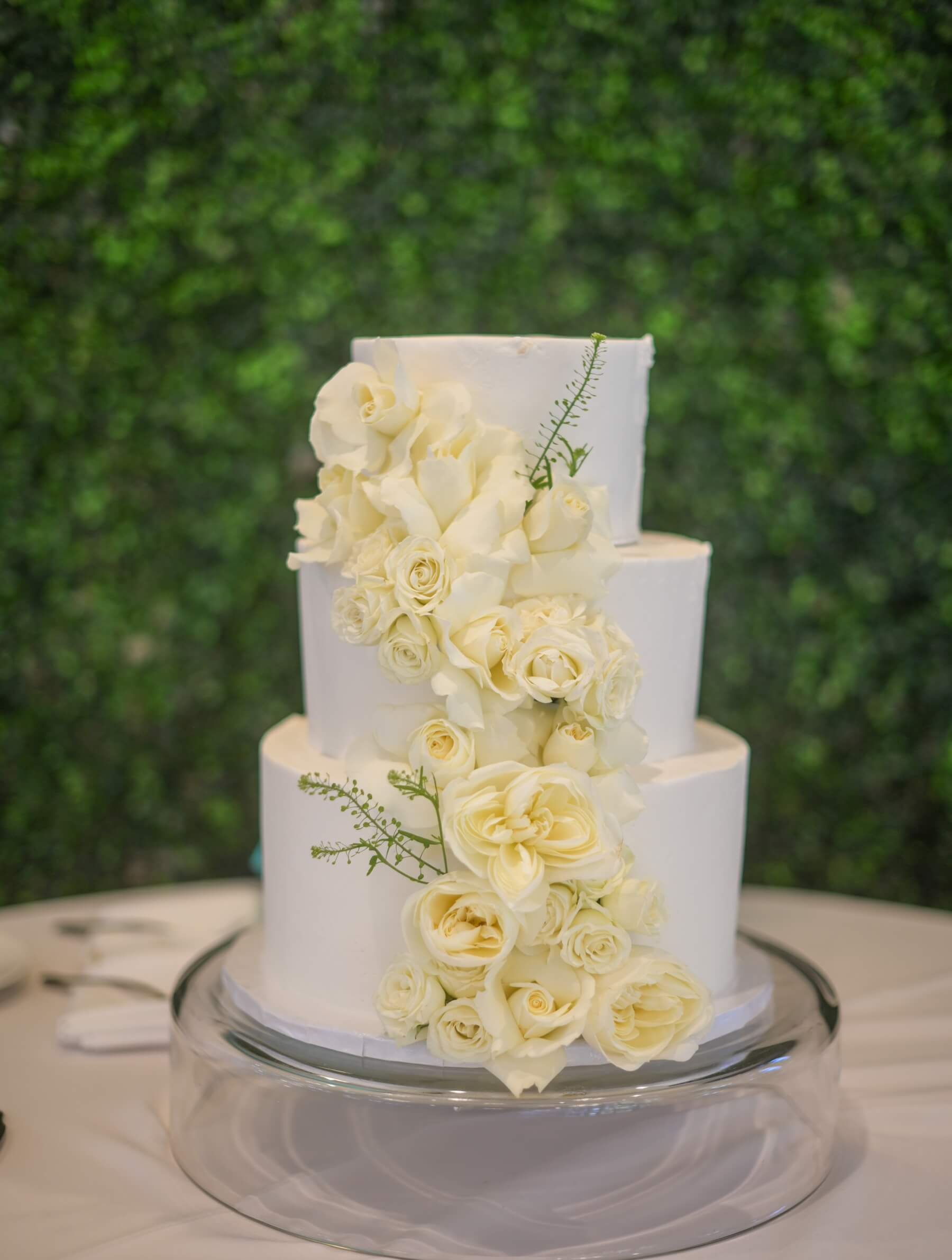 Three tier white wedding cake with white flowers 