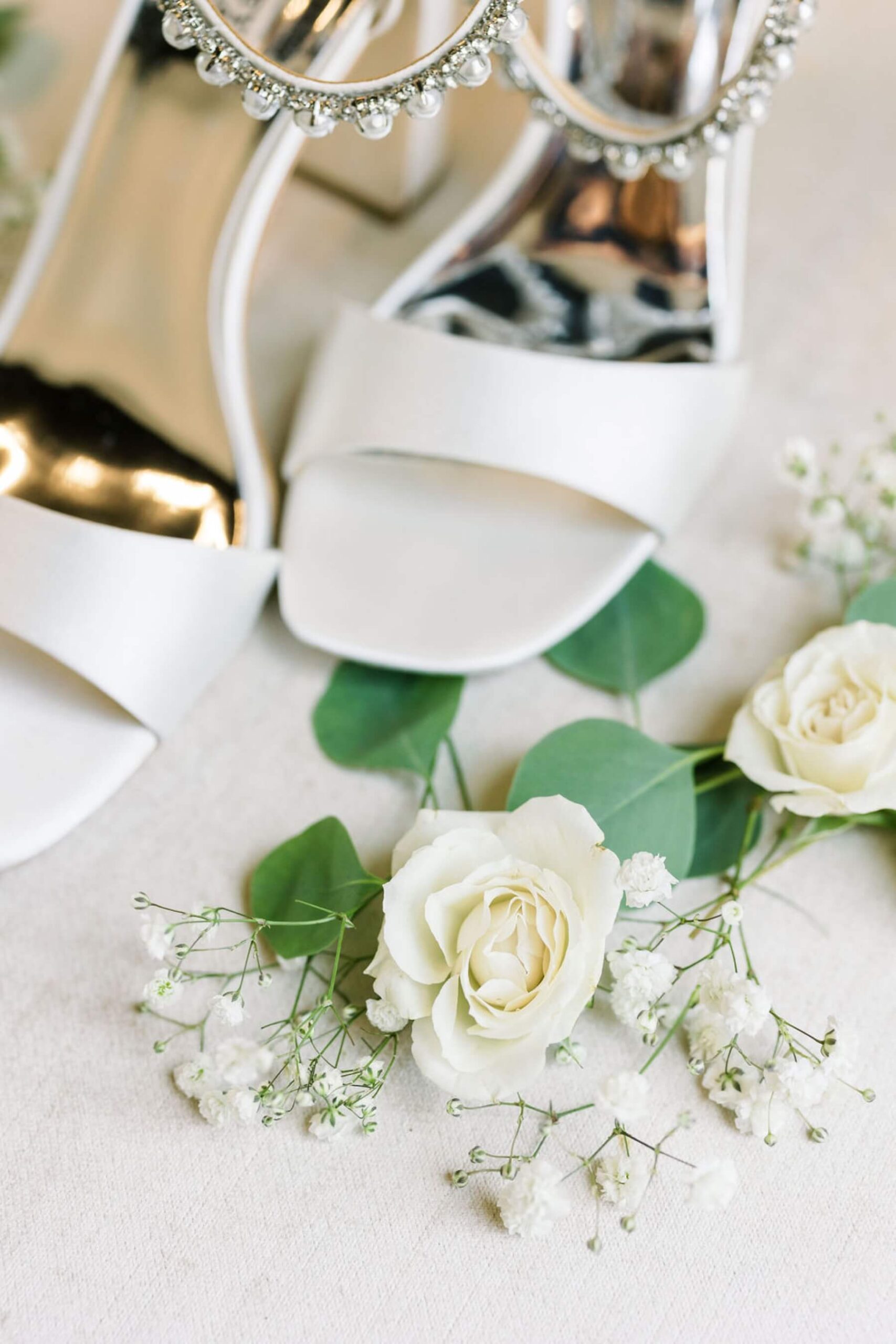 White Badly Mischka bridal shoes with white rose and baby's breath