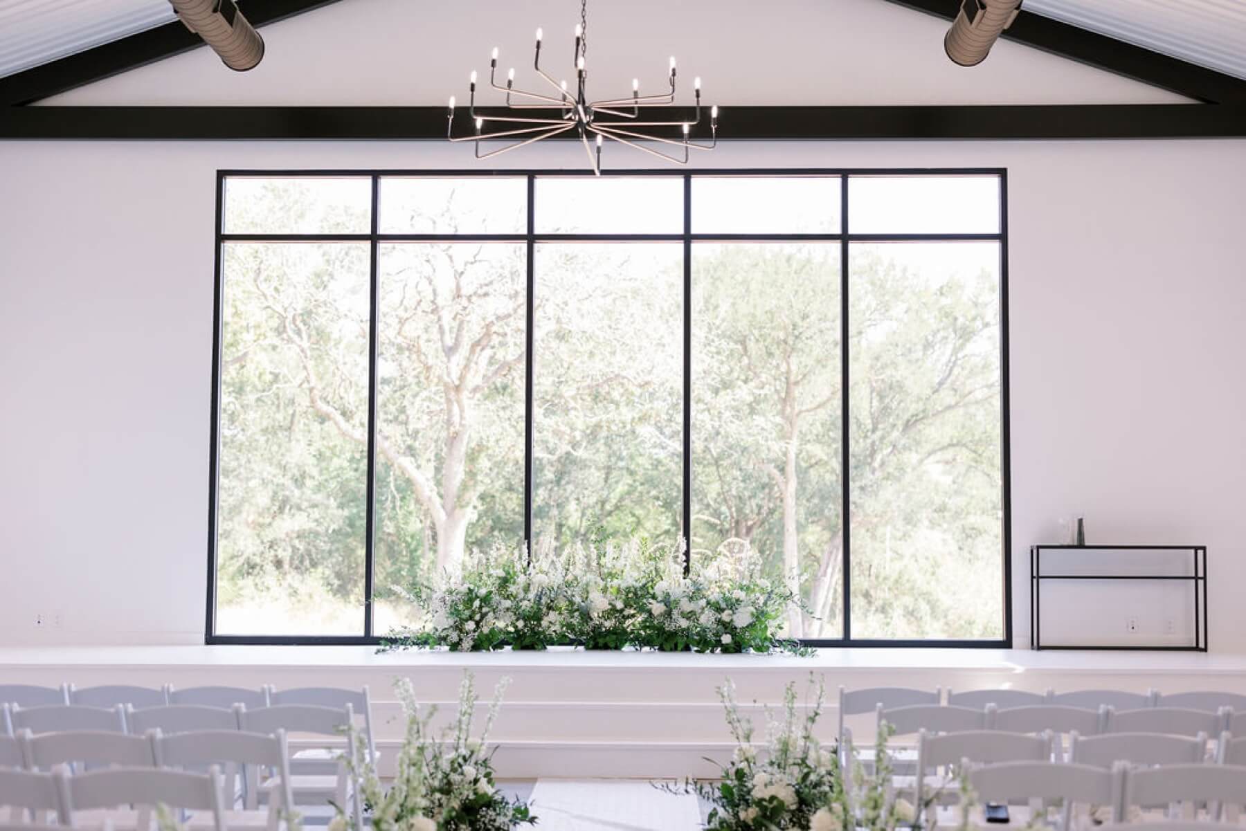 White floral arrangement with greenery as backdrop background at chapel at Union House TX