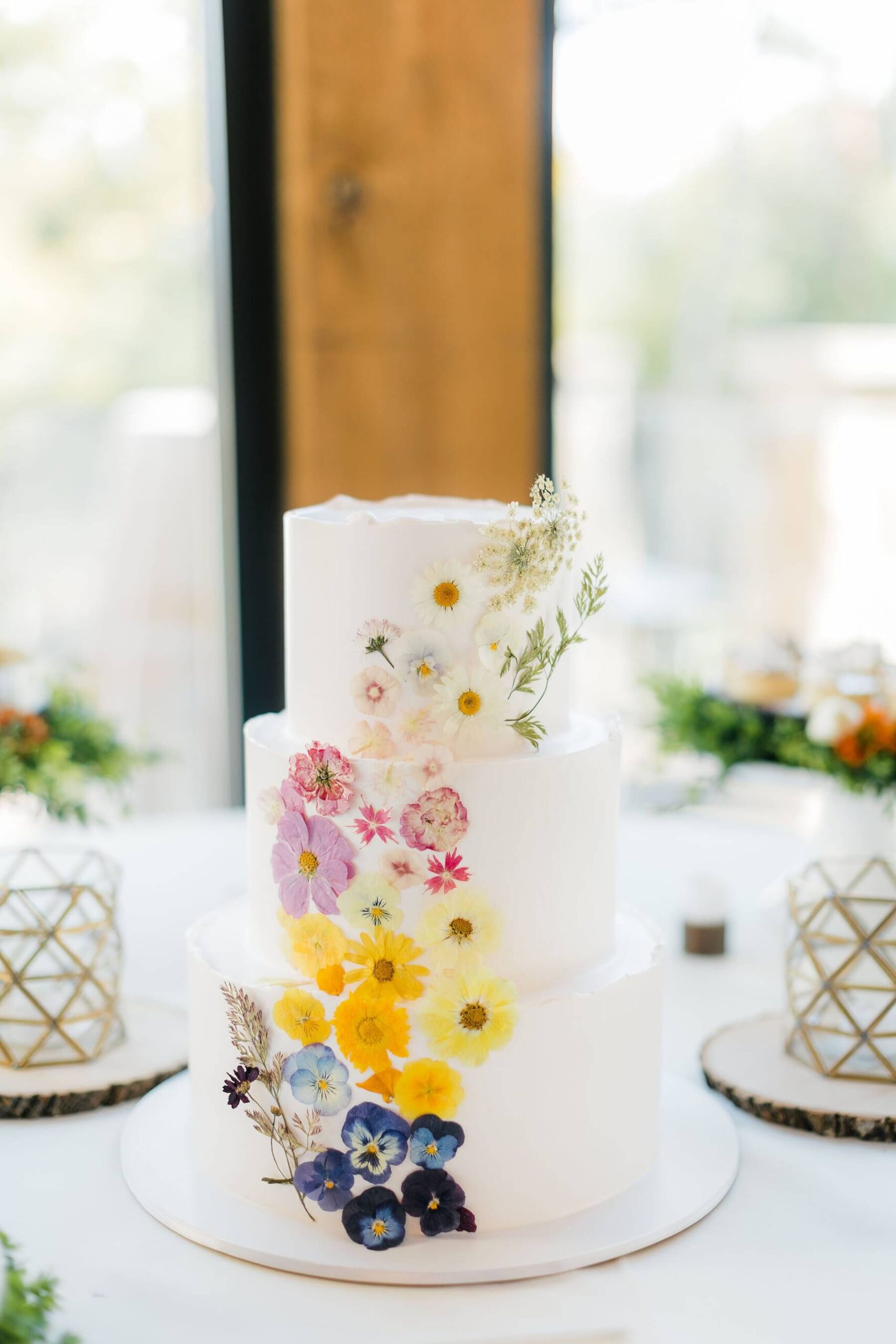 Three tier wedding cake with dried flowers in 2024 wedding trends post