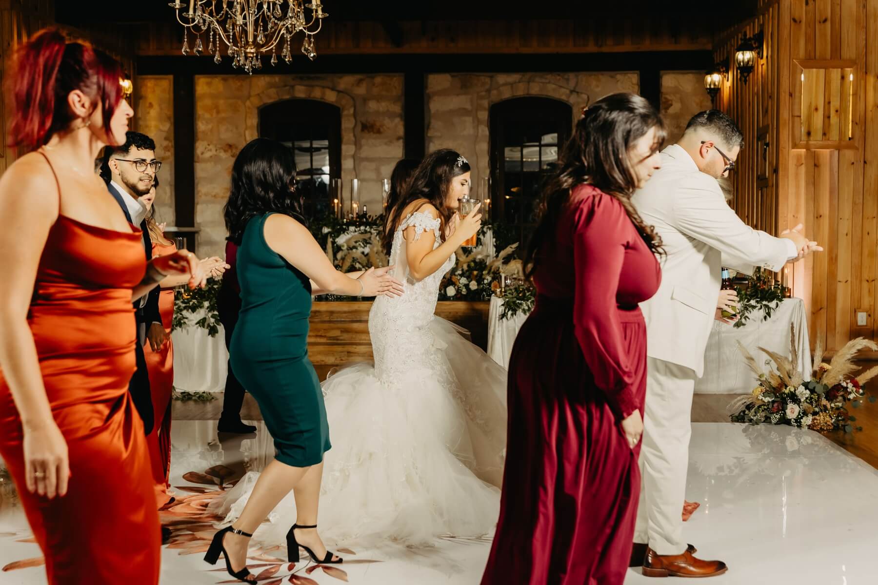 Woman in wedding dress dancing with wedding guests