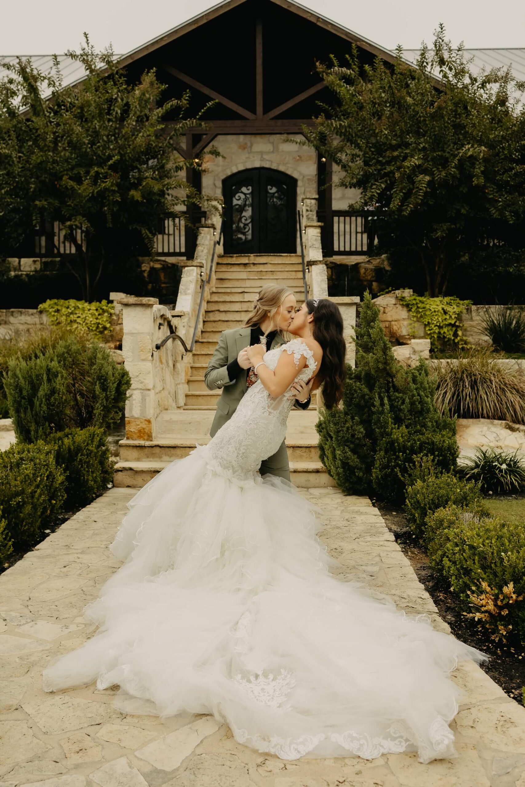 Couple kissing in front of The Springs McKinney Stone Hall