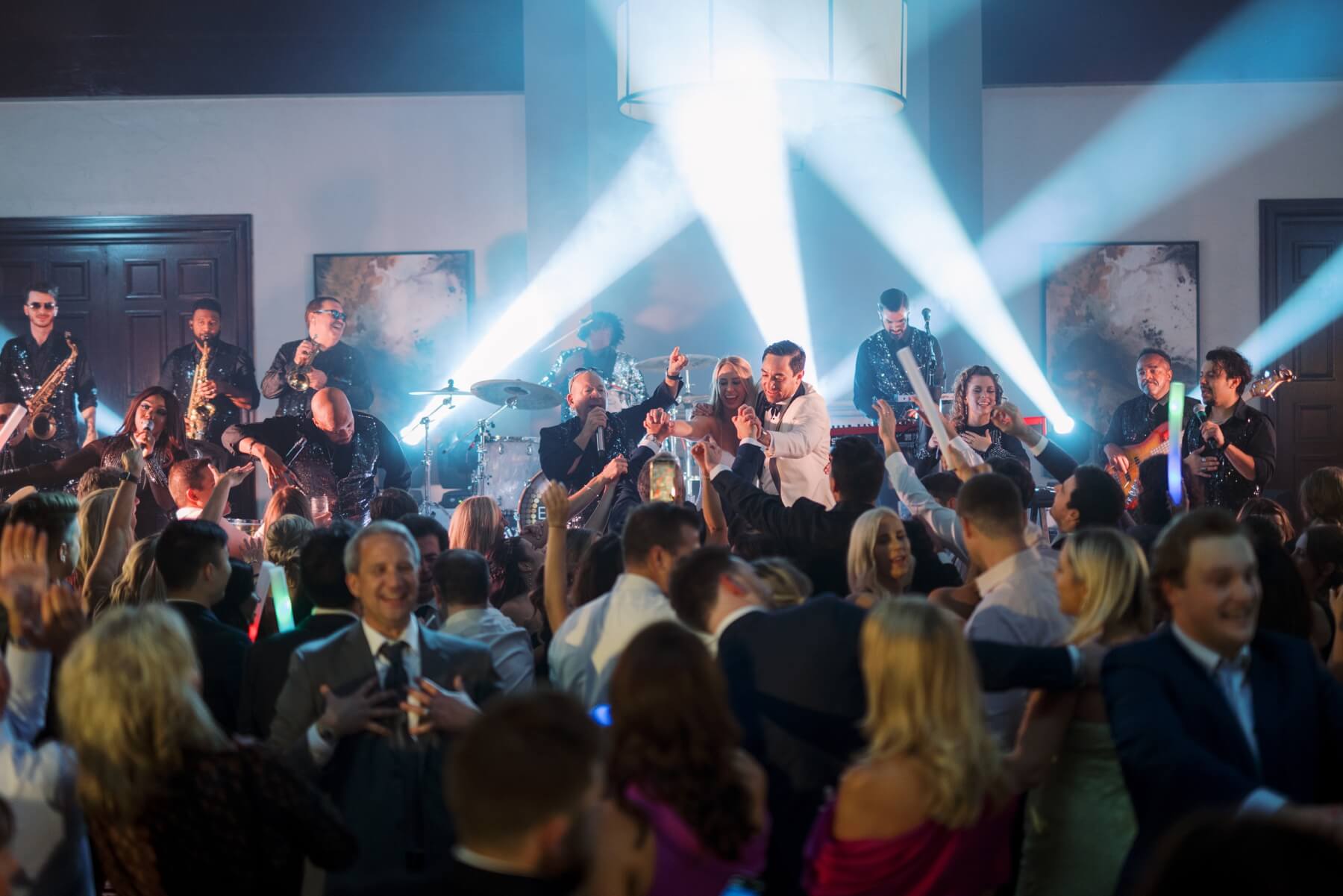 Couple dancing on stage with band during wedding reception