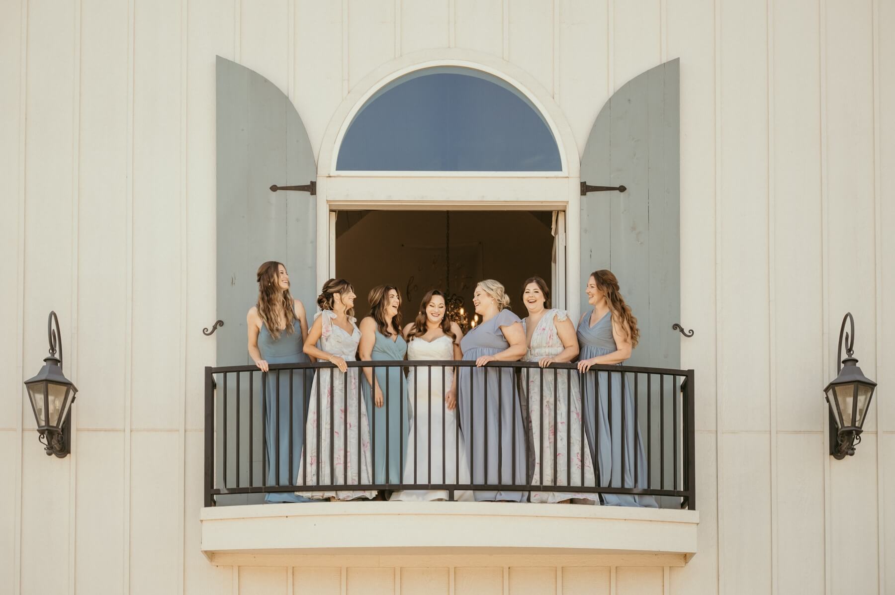 Bride and bridesmaids on the balcony of The French Farmhouse Venue