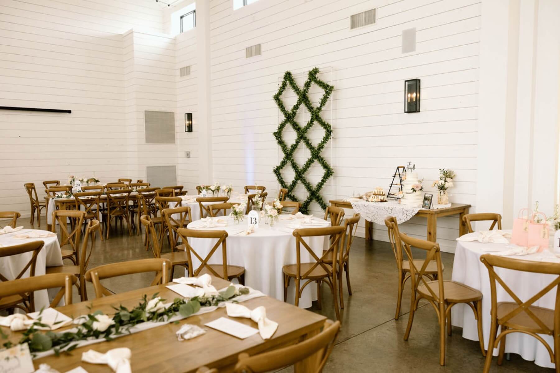 Reception set up at The Gardenia featuring farmhouse and round tables with cross back chairs