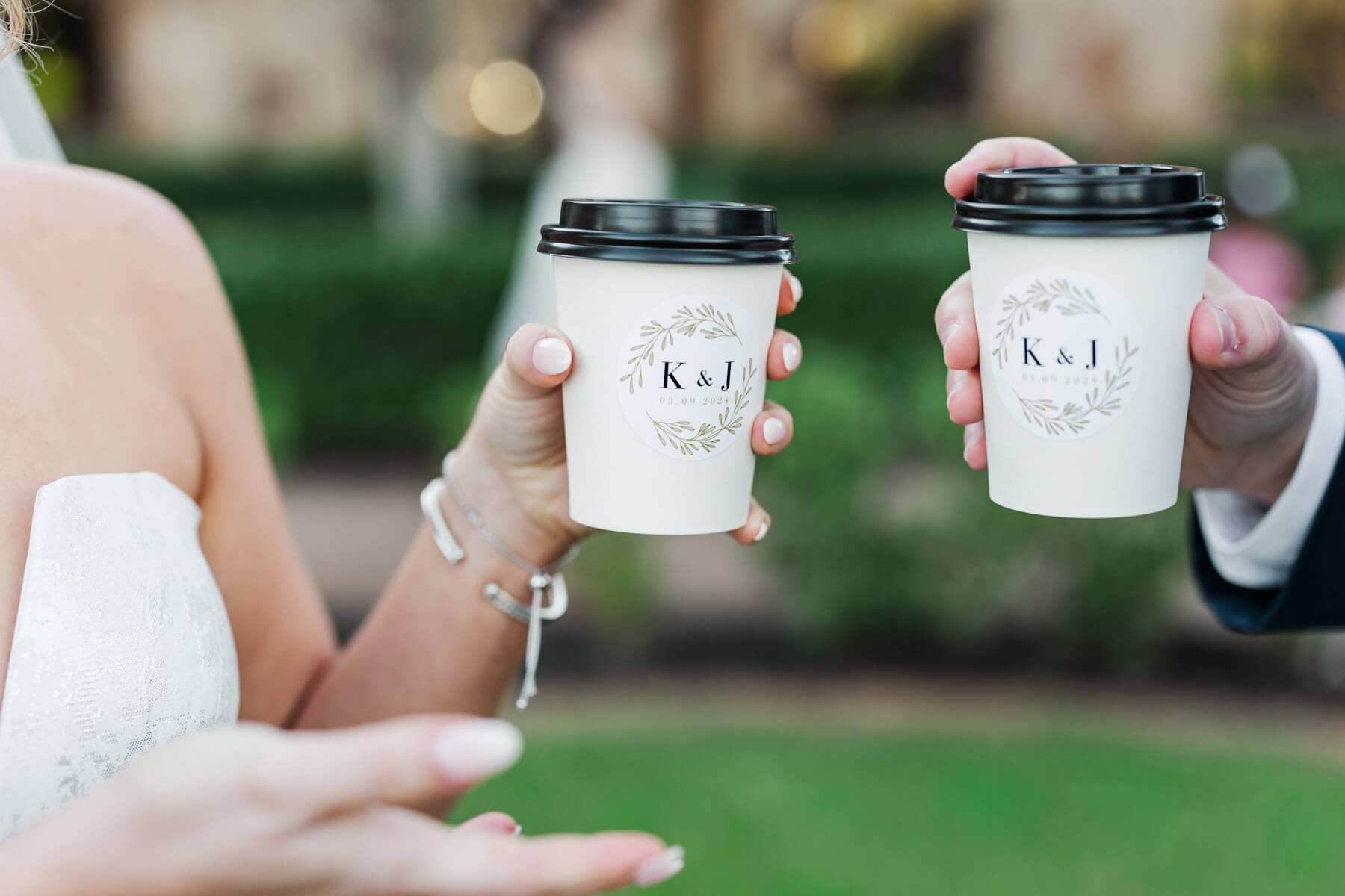 Bride and groom holding custom coffee cups from coffee cart at wedding