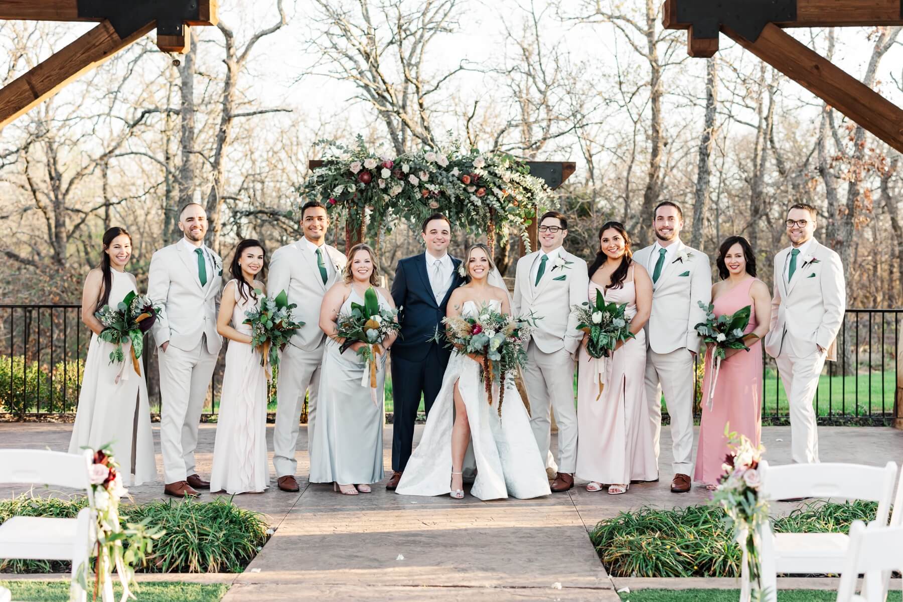 Bride and groom with wedding party at outdoor ceremony area at The Springs in Denton