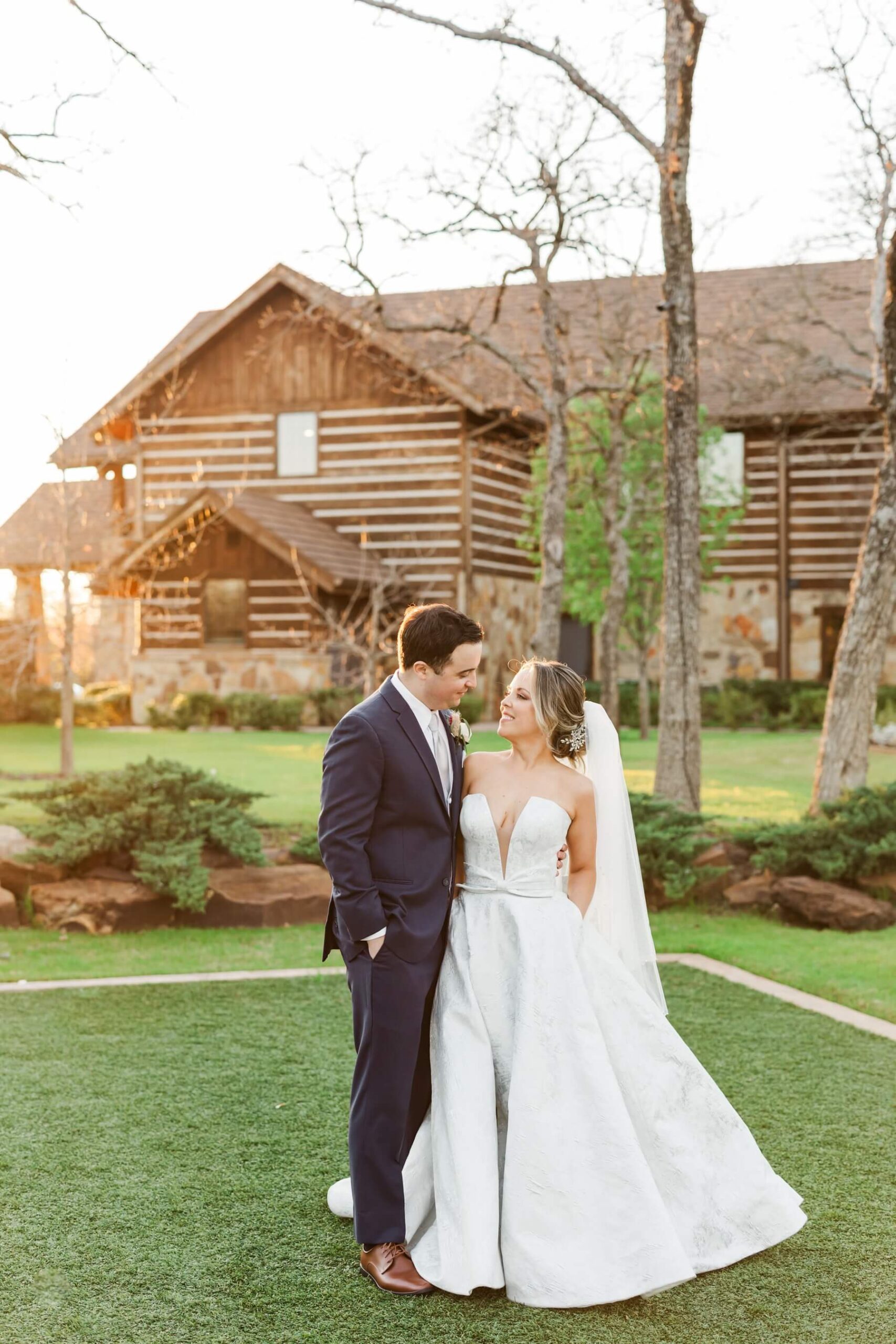 Bride and groom looking at each other in front of The Lodge at The Springs in Denton