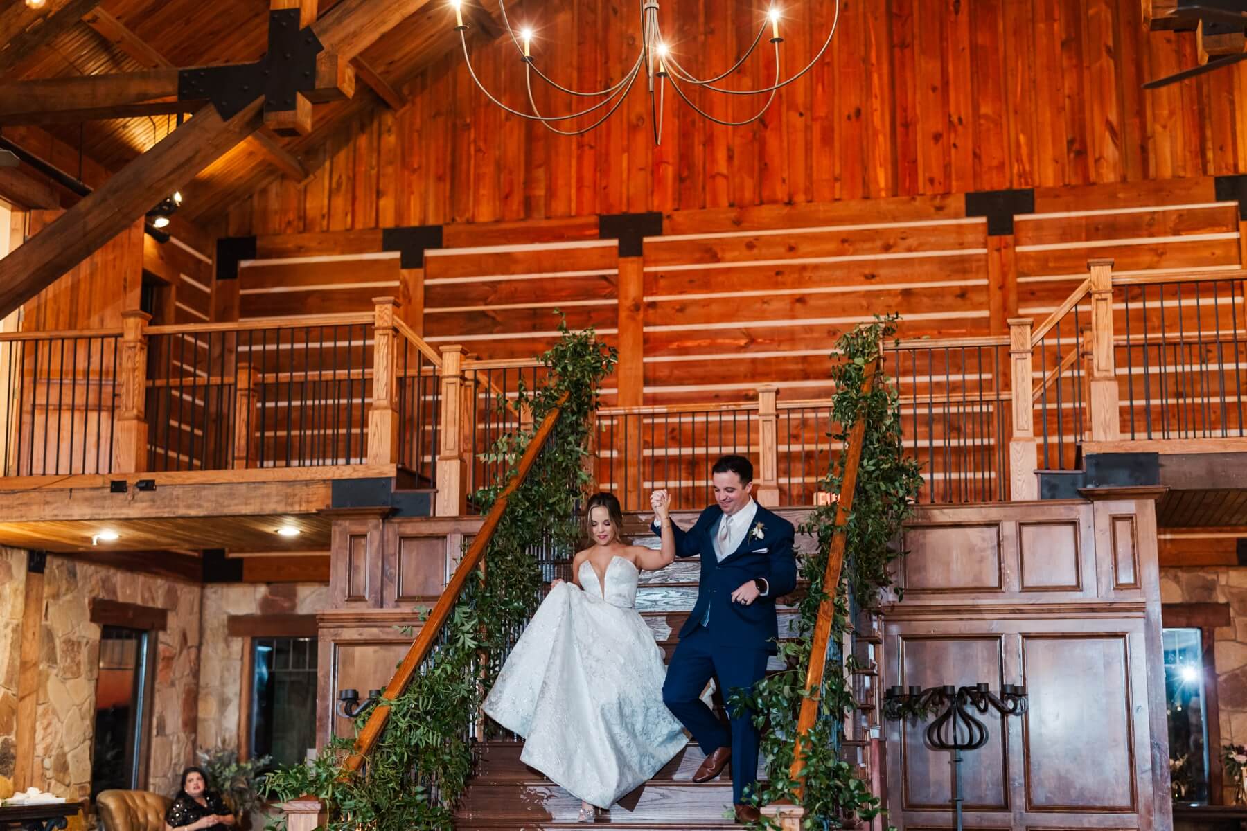 Bride and groom making grand entrance down the stairs of The Springs in Denton