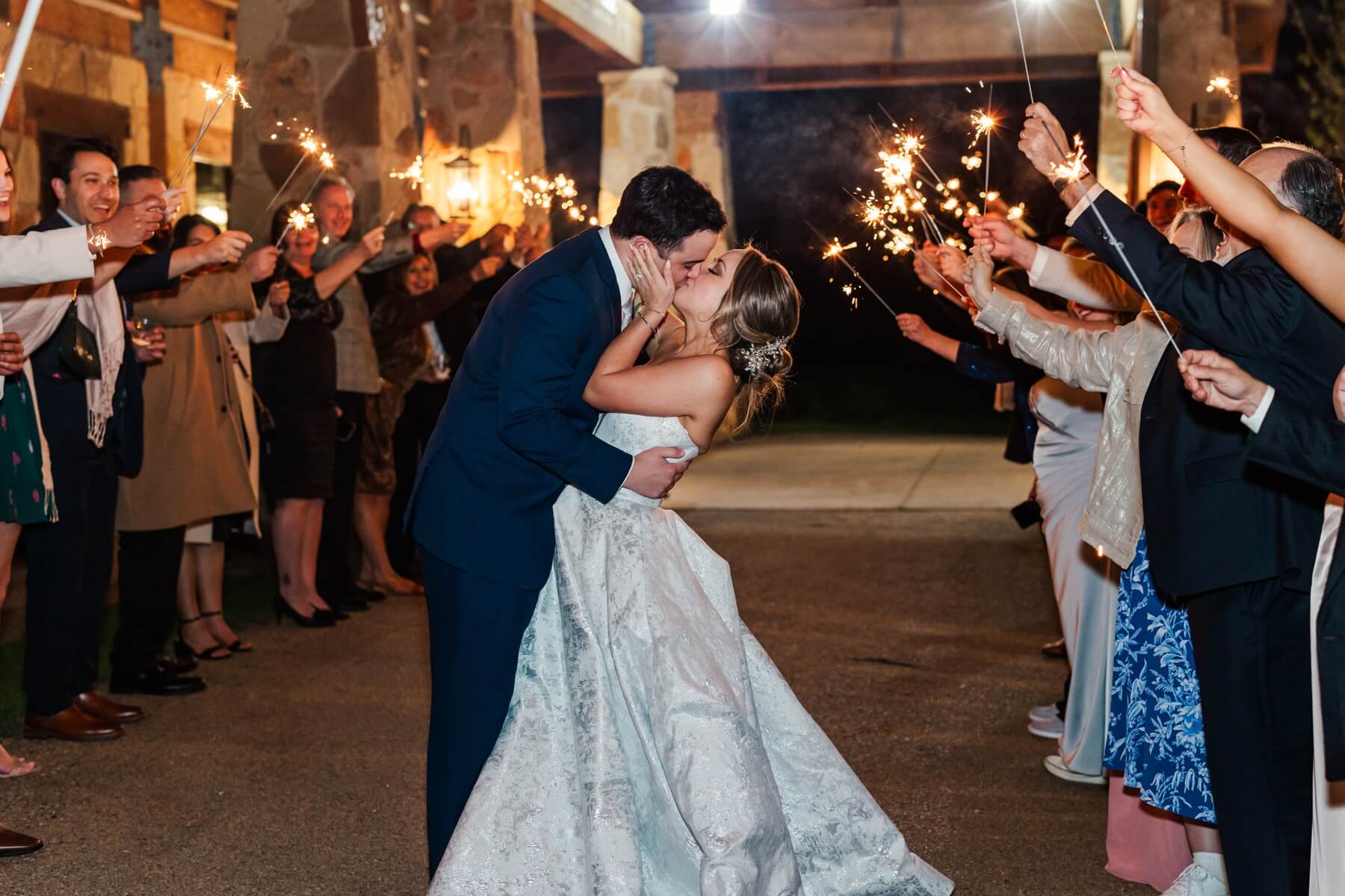 Bride and groom kissing during sparkler exit at The Springs in Denton