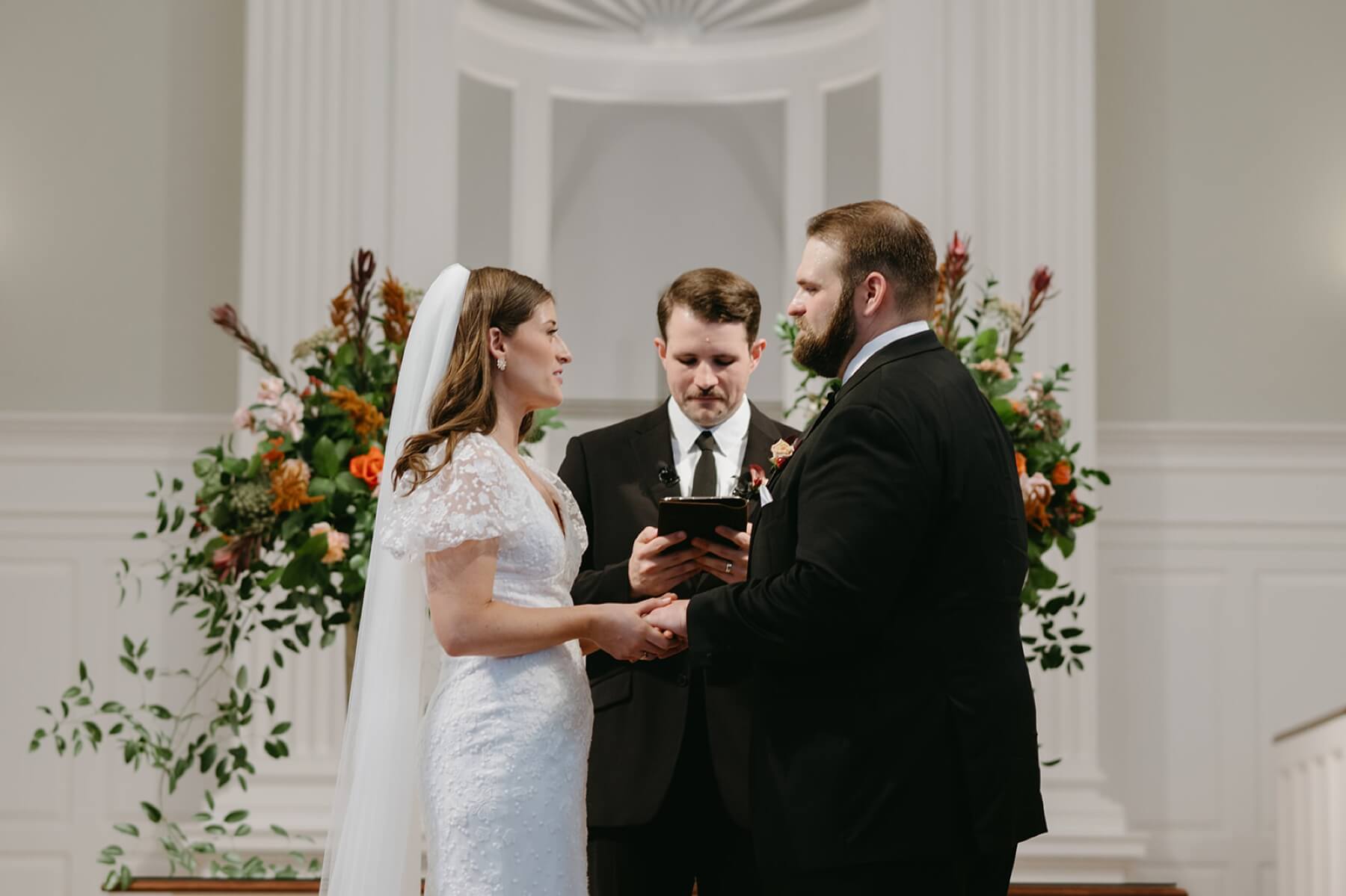 Bride and groom holding hands at the altar at Robert Carr Chapel