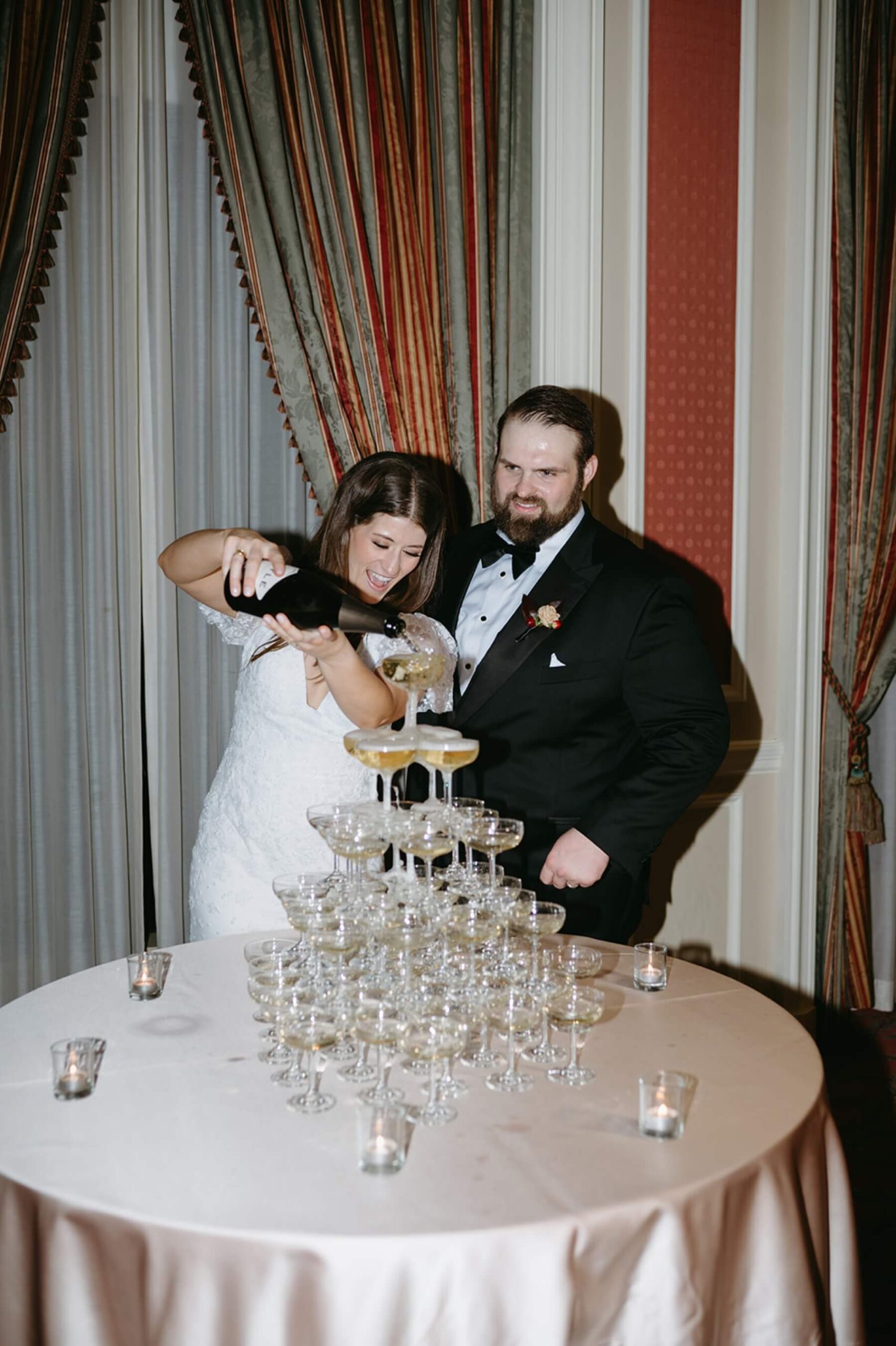 Bride pouring champagne over champagne tower