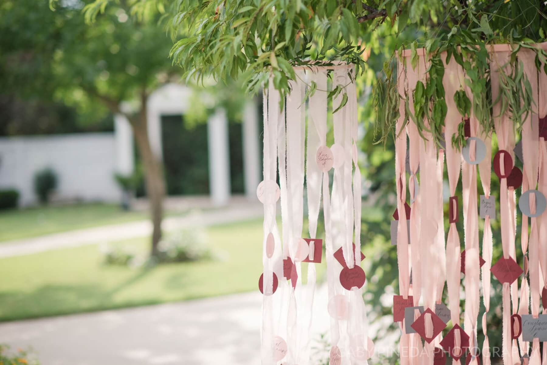 Ribbon seating chart hanging from a tree