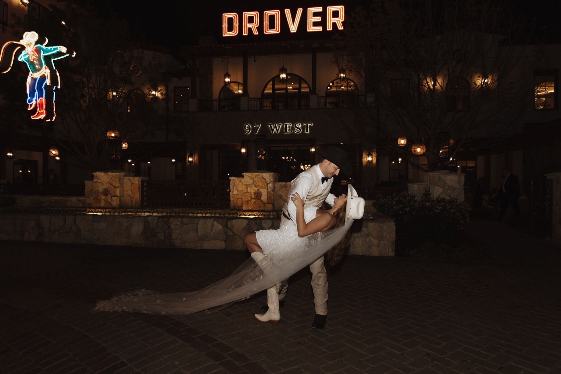 Groom dipping bride in front of Hotel Drover