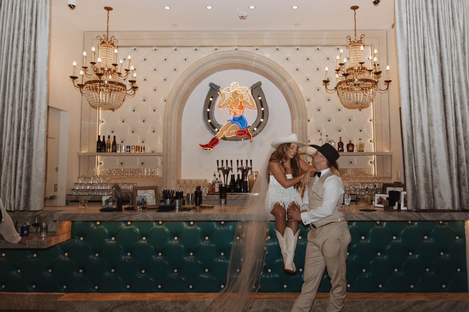 Bride sitting bar at Hotel Drover with groom standing next to her