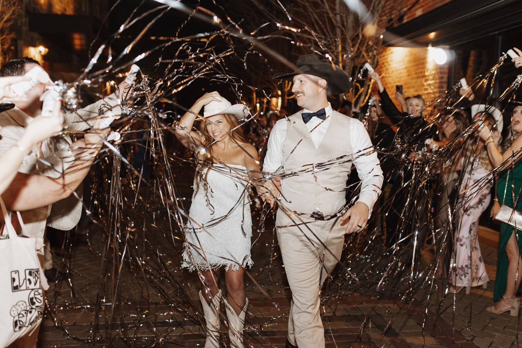 Bride and groom exiting with silver streamers